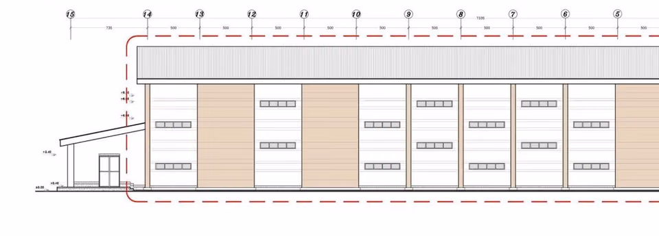 Long facade elevation of the pump station with low windows and alternating wall panels.